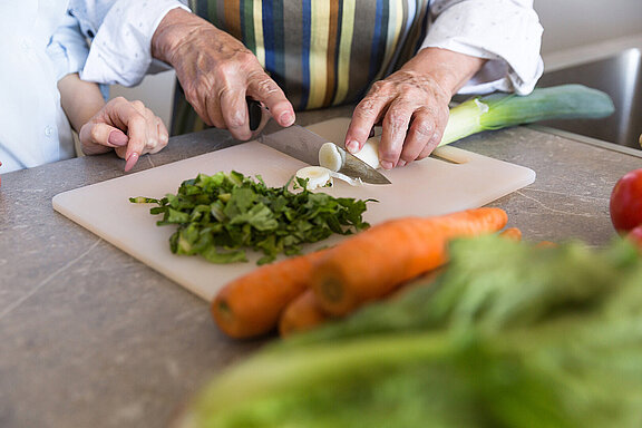 Gemüse_schneiden_Ernährung_Alter_close-up-senior-lady-cutting-vegetables-board.jpg 